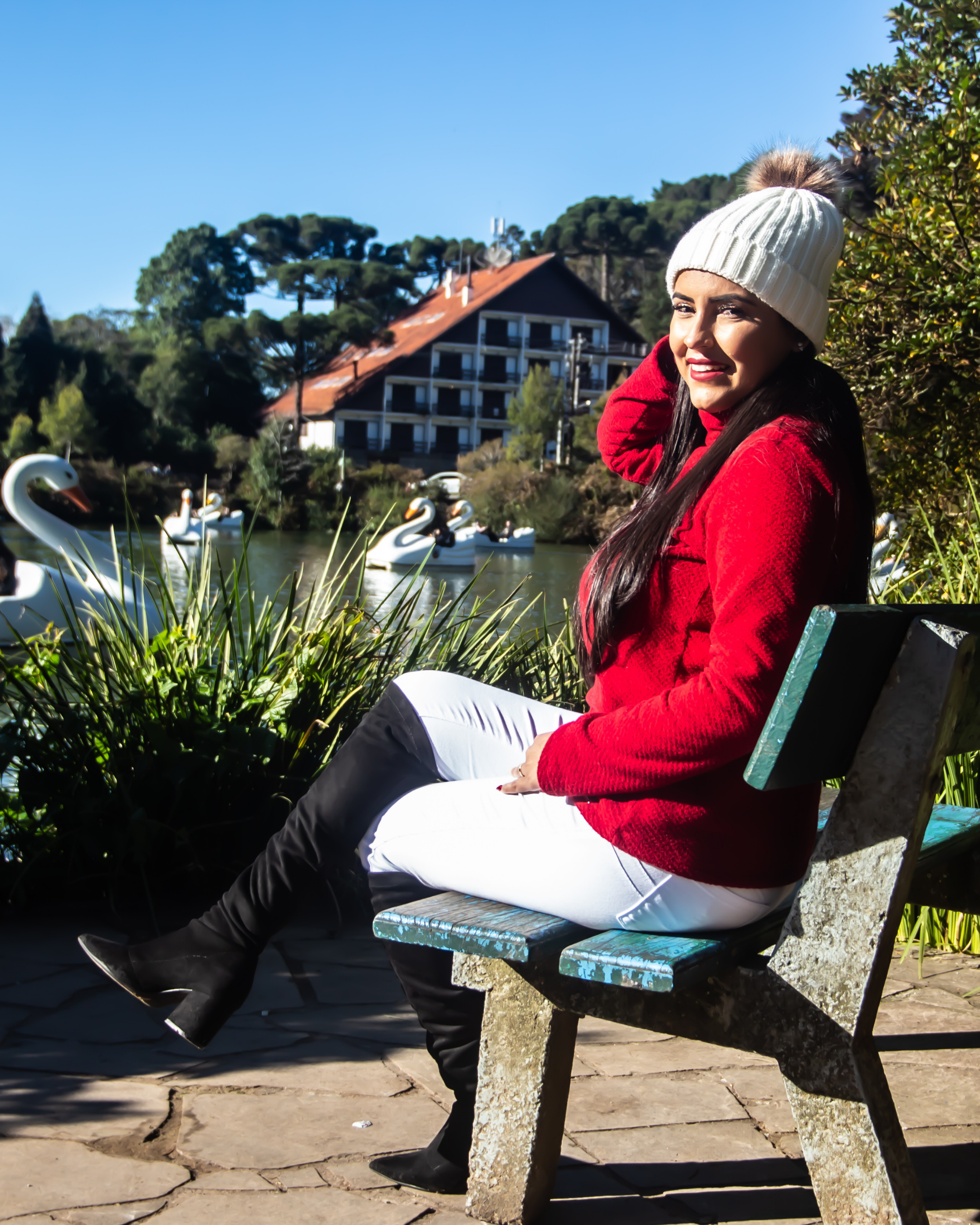 Menina sentada em um banco de frente para o Lago Negro em Gramado